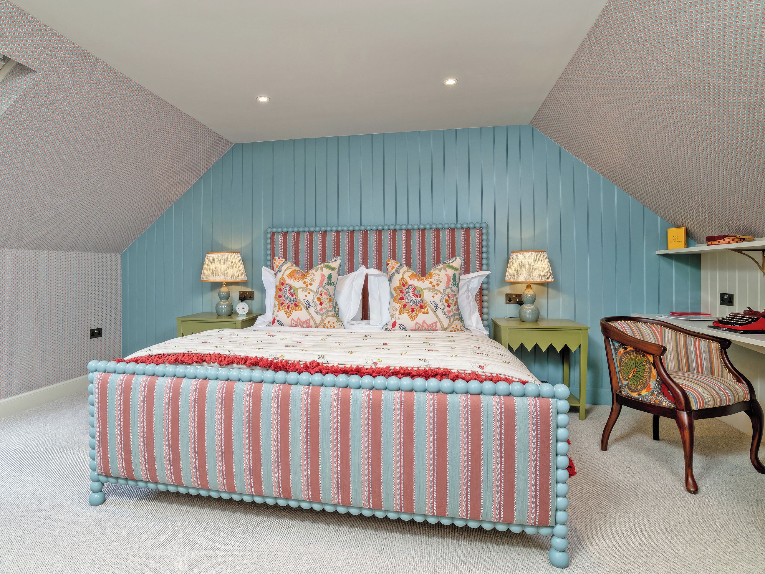 A bedroom with a bed, two bedside tables, a chair, and a desk.