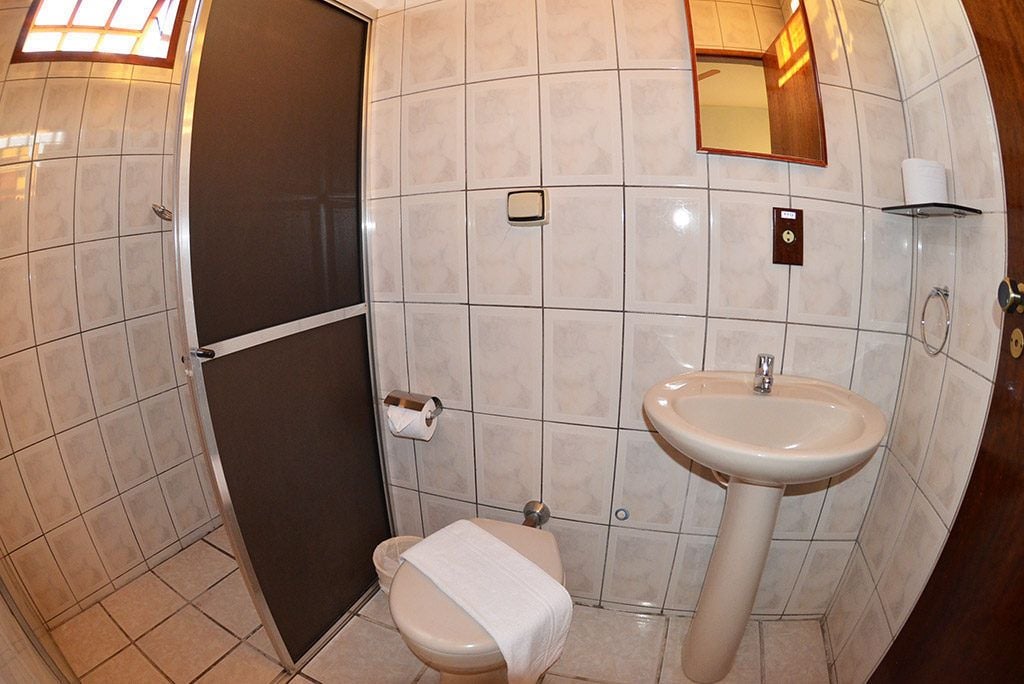 Un baño con inodoro, lavamanos y espejo.