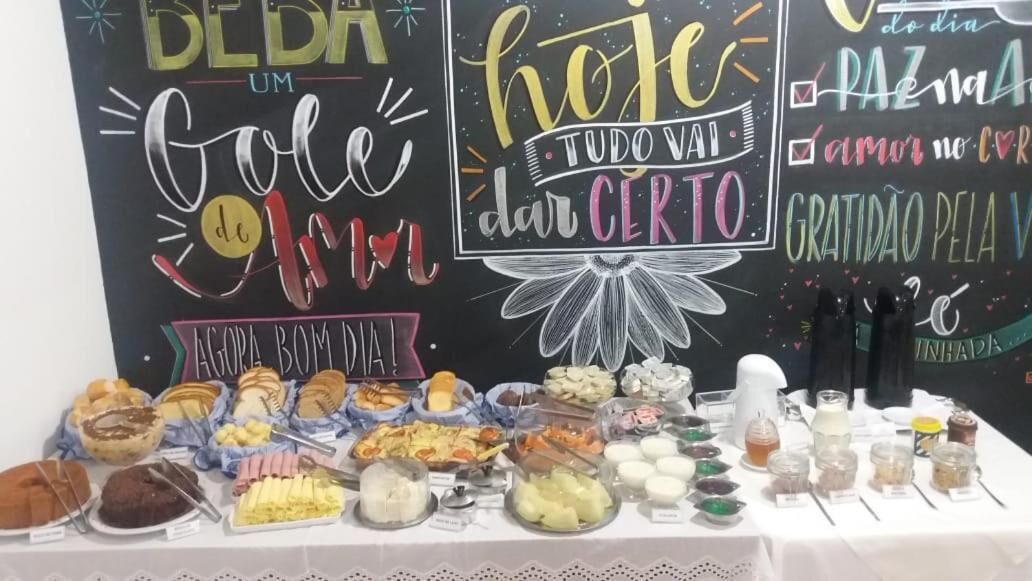 A buffet table with various food items and a chalkboard with inspirational messages.