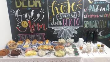 A buffet table with various food items and a chalkboard with inspirational messages.