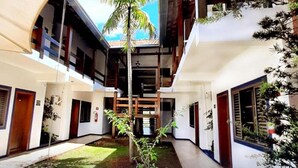 Un bâtiment moderne doté d’une cour intérieure, de nombreux balcons et de plantes en pot.