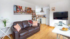 Ein modernes Wohnzimmer mit einer braunen Ledersofa, einem weißen Couchtisch und einem Stadtbild.