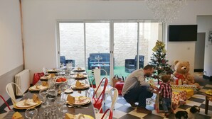 A dining area with a table set for a meal, a Christmas tree, and a teddy bear. - Notre Dame Chauvigny - Chambres d'hôtes (Chauvigny)