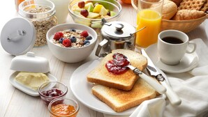 A breakfast setting with toast, jam, butter, cereal, fruit, orange juice, coffee, and croissants. - Notre Dame Chauvigny - Chambres d'hôtes (Chauvigny)