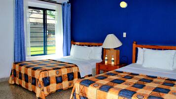A hotel room with two beds, a nightstand, a lamp, and a window with curtains.