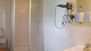 A bathroom with a shower, toilet, and sink. - Family-friendly terraced house with fireplace, WiFi, sauna, pets allowed (Ostseebad Prerow)