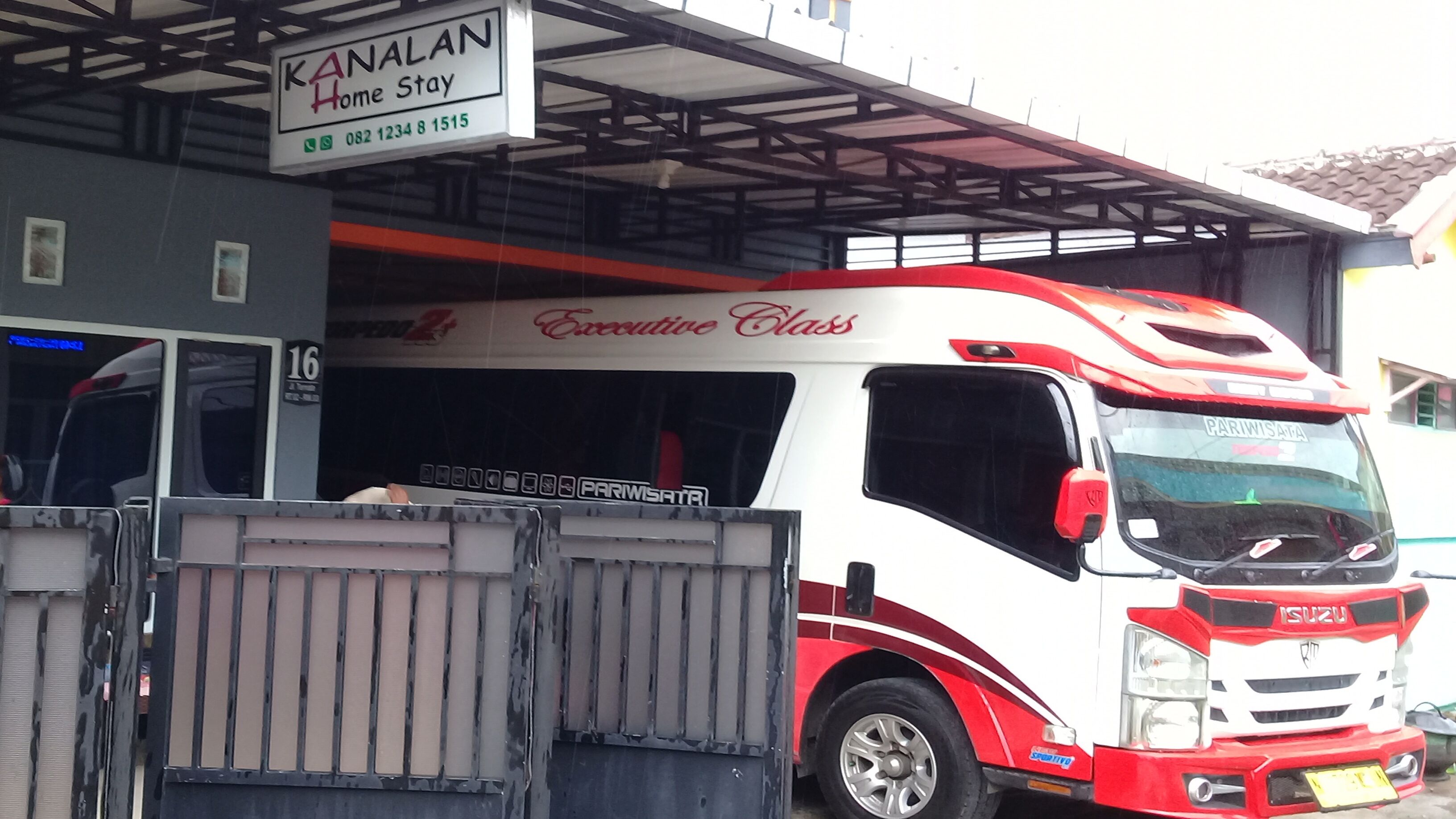 A bus with "Executive Class" written on the side parked at a bus station.