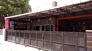A hotel with a covered entrance, a signboard with the name 'KANALAN Homestay BANYUWANGI', and a metal fence in front. - Kanalan Homestay (Banyuwangi)
