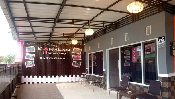 A covered outdoor seating area with a sign for KANALAN Homestay BANYUWANGI. - Kanalan Homestay (Banyuwangi)