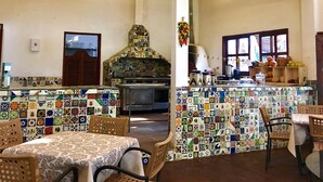 A kitchen with a tiled backsplash, hanging pots, and a stove.