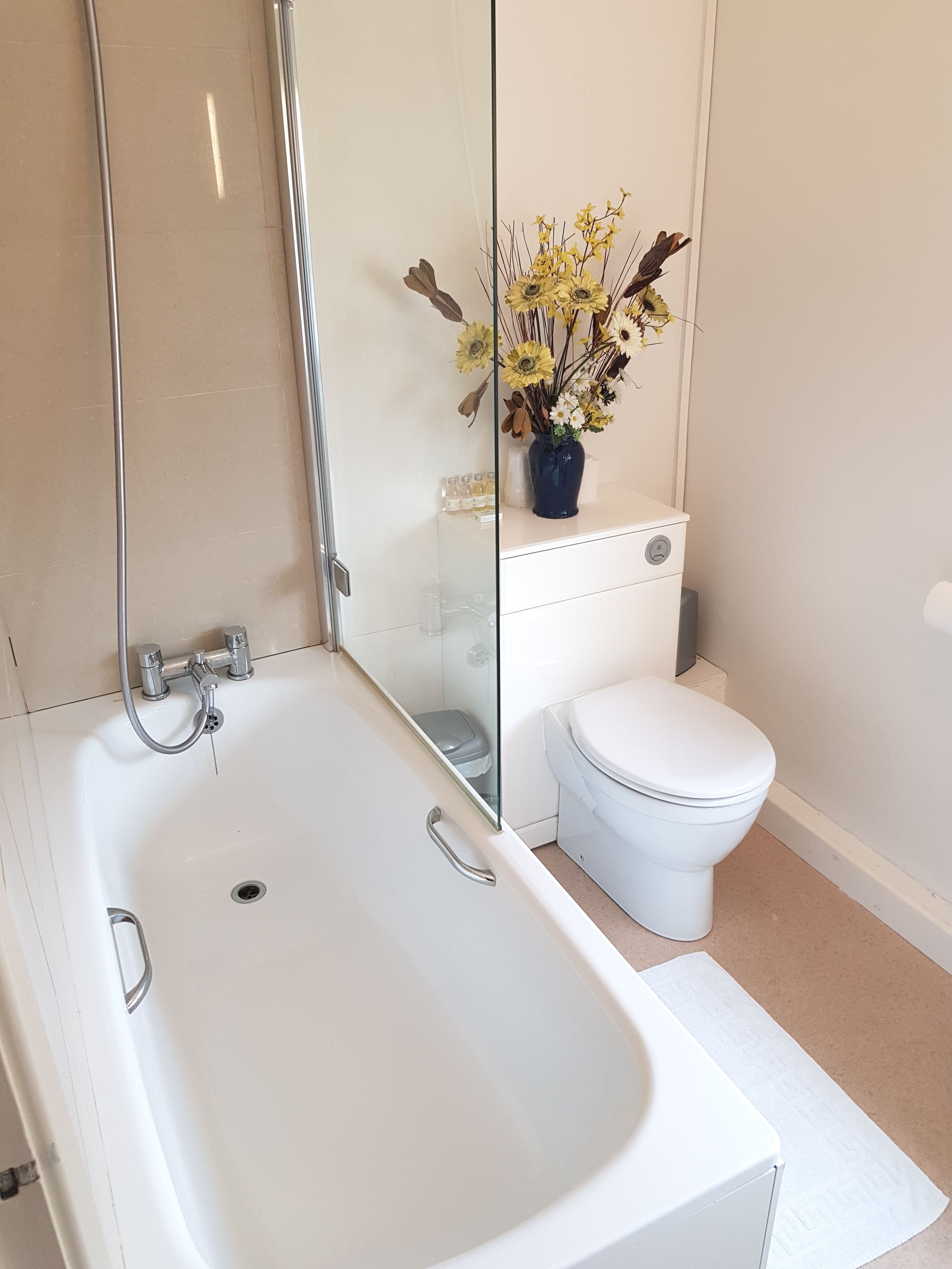 Une salle de bain avec une baignoire blanche, des toilettes et une cabine de douche en verre.