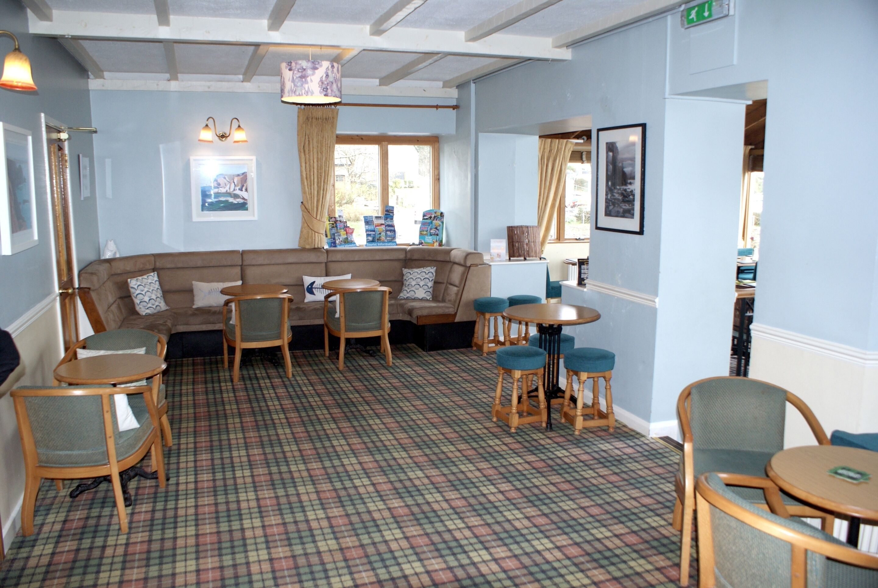 A room with a plaid carpet, a sofa, and several chairs.
