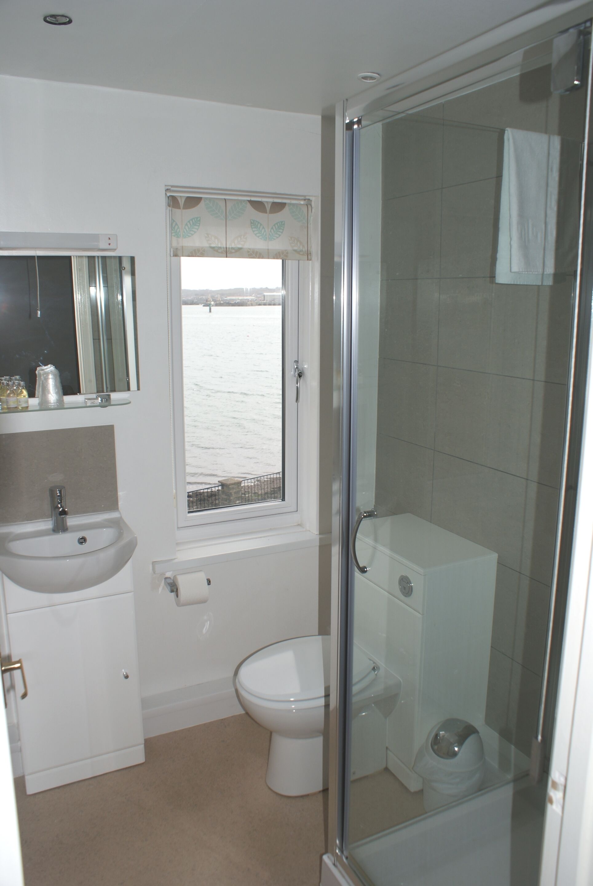 A bathroom with a sink, toilet, and shower.