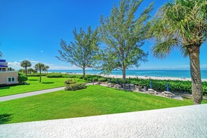 Une propriété située en bord de mer, dotée d’une pelouse bien entretenue, d’un espace extérieur aménagé pour s’asseoir et offrant une vue sur l’océan.