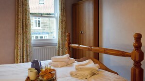 A neatly made bed with towels, a tray of croissants, and a cup, suggesting a breakfast setup. - 3 bedroom accommodation in Staithes, near Saltburn-by-the-Sea (Staithes, near Saltburn-by-the-Sea)