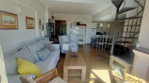 Un salon comprenant un canapé, une table basse et un coin repas avec des chaises et une table.