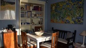 A dining area with a table, chairs, a bookshelf, and a painting on the wall. - Enjoy breathtaking view and sunsets from the Swimming pool - Casa Magnolia LUNA (MORRONA, TERRICCIOLA)