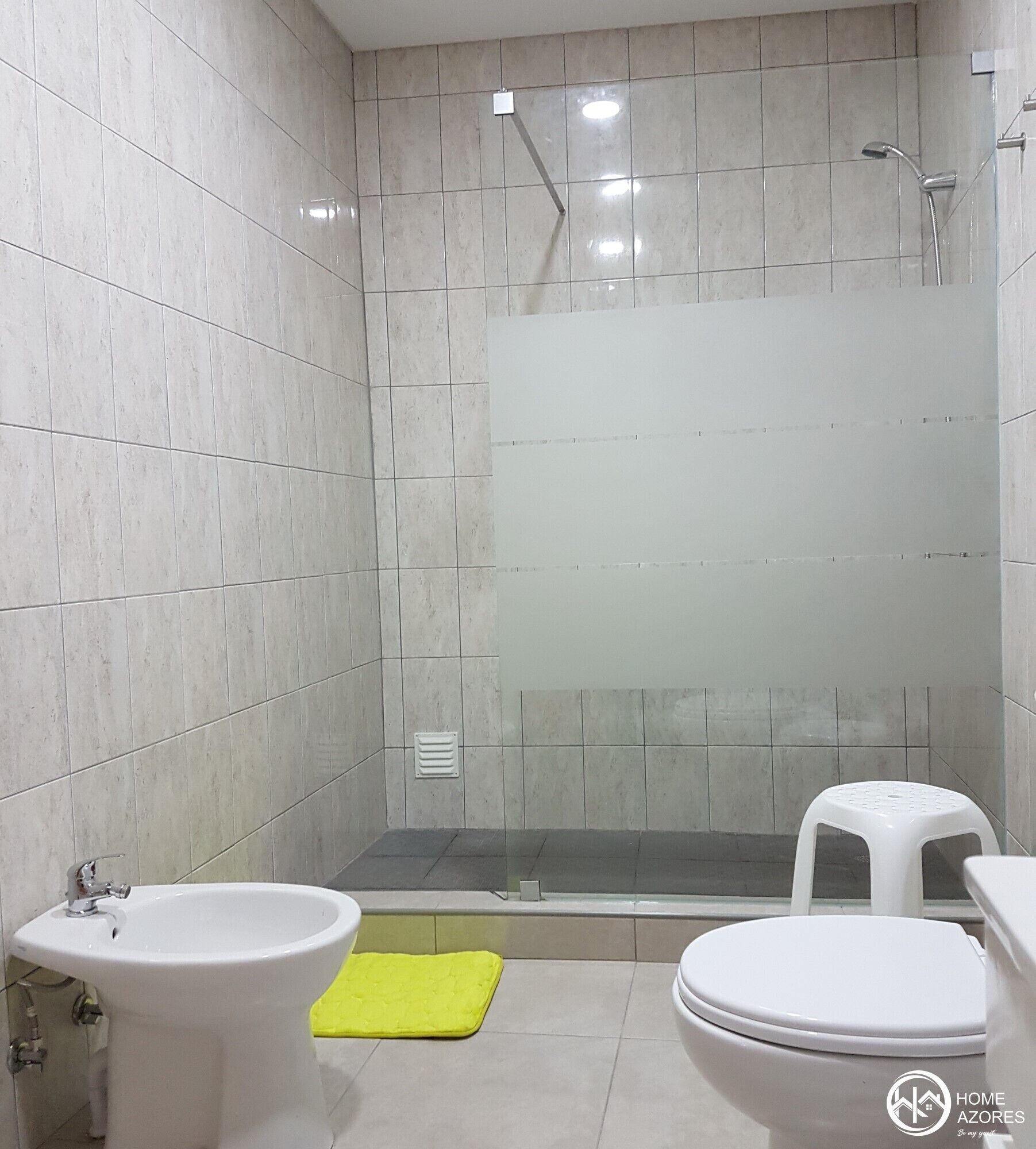 A bathroom with a toilet, bidet, and shower.