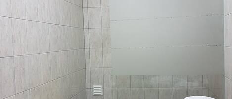 A bathroom with a toilet, bidet, and shower.