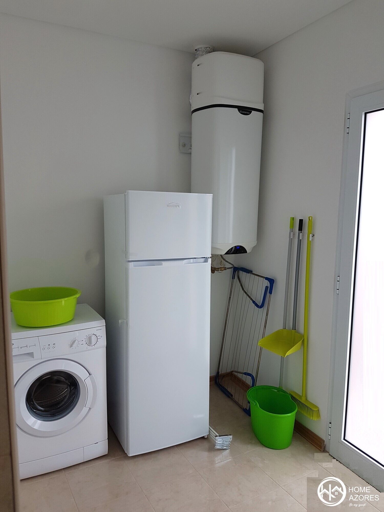 A compact laundry area with a washing machine, a white refrigerator, and a water heater.