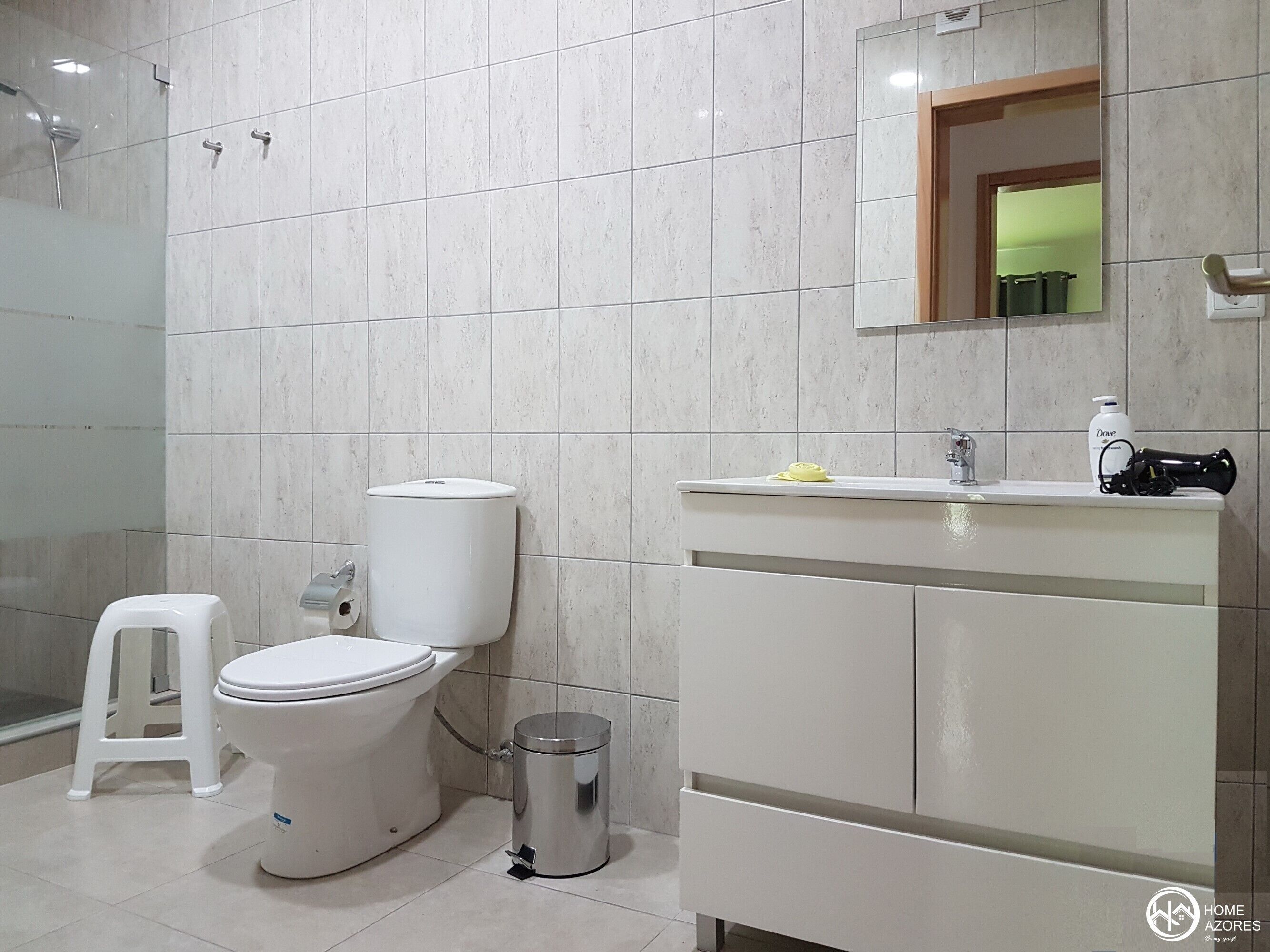 Un bany modern amb vàter, rentapel i plat de dutxa.