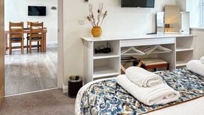 Une chambre d’hôtel avec un lit, une télévision, un bureau et une chaise.