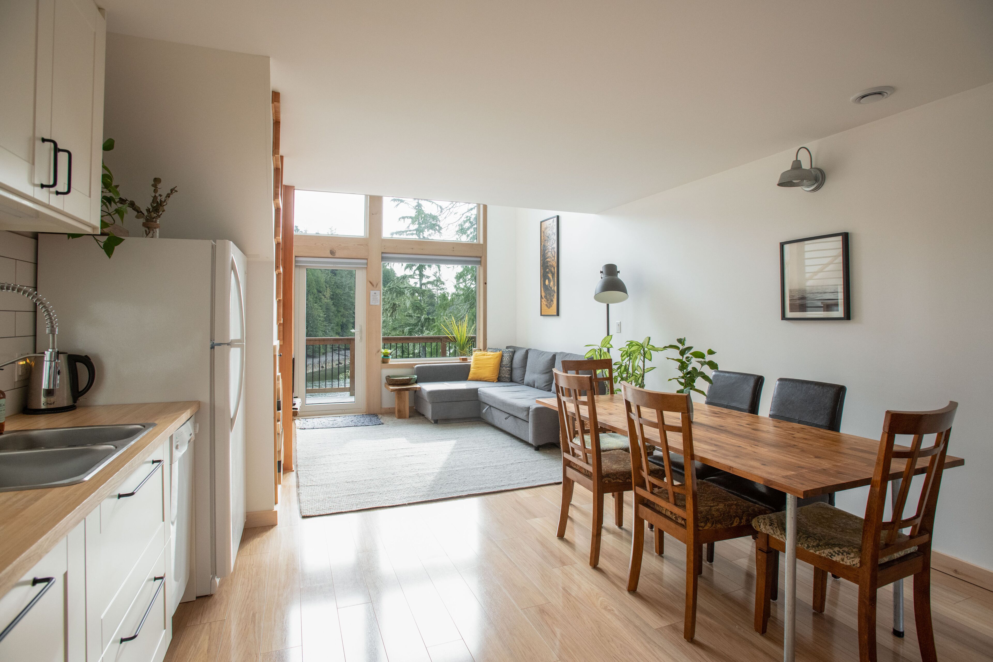 A modern kitchen with a wooden countertop, a built-in dishwasher, and a large window.