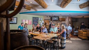A restaurant with wooden tables and stools, a bar area, and a television screen. - Great Value! Well-Equipped Condo in Crested Butte (Crested Butte)