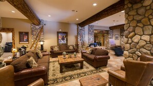 A spacious living room with leather sofas, a coffee table, and stone walls. - Great Value! Cozy & Rustic Studio in Crested Butte (Crested Butte)