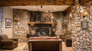 A stone-walled room with a fireplace, leather seating, and a wooden table. - Great Value! Cozy & Rustic Studio in Crested Butte (Crested Butte)