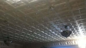 A restaurant with a high ceiling, green upholstered seating, and a large TV screen. - Hotel Hamilton - Kaly Center (Hammamet)
