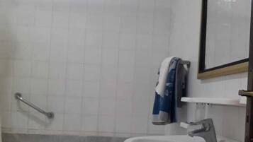 A bathroom with a bathtub, a sink, and a mirror.