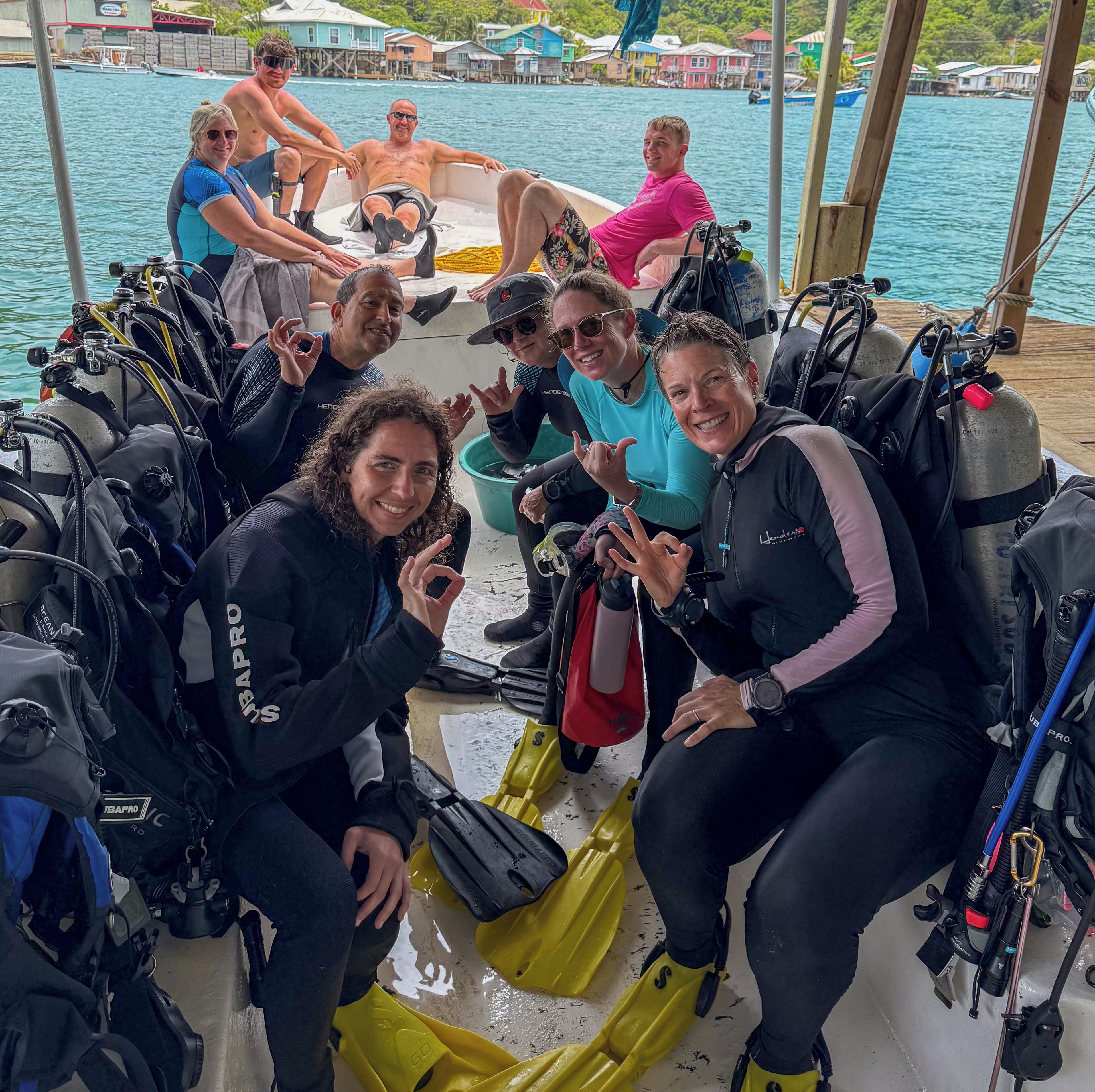 Un grupo de personas en un bote con equipo de buceo y aletas.