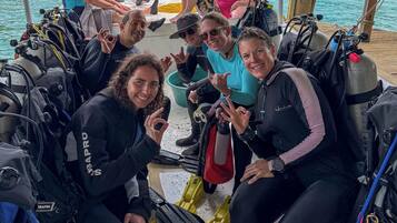 Un grupo de personas en un bote con equipo de buceo y aletas.