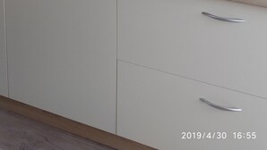 Angolo cottura con microonde, piano cottura a induzione e schienale in legno.