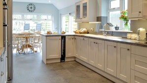 A modern kitchen with built-in appliances, a dining area with chairs, and a view of the outdoors. - 3 bedroom accommodation in Gatehouse of Fleet, near Kirkcudbright (Gatehouse of Fleet, near Kirkcudbright)