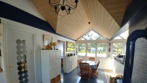 Eine moderne Küche mit Essbereich, Holzboden und großen Fenstern.