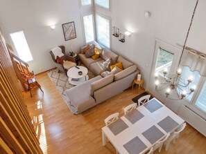 Uma sala de estar moderna com sofá, mesa de centro e área de jantar.