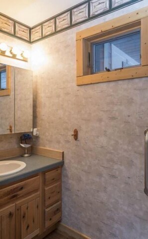 Een bad/douchecombinatie, een haardroger, handdoeken