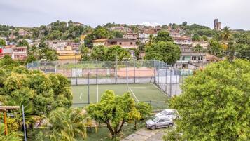 Una cancha de tenis rodeada de árboles y edificios.
