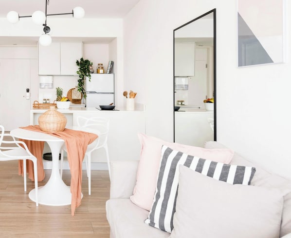 A modern kitchen with white cabinets, a dining area with a white table and chairs, and a living area with a white sofa and cushions. - Top Rentals Belgrano (Buenos Aires)