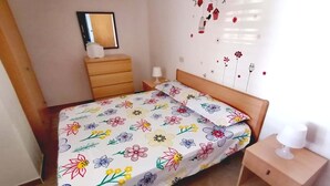 A bedroom with a bed, a nightstand, a dresser, a mirror, and a wall with floral decorations. - Apartment nr. 2 in Villa Daniel, surrounded by greenery in VIESTE Gargano in P. (Vieste)