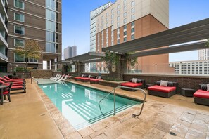 Una piscina al aire libre, camas de piscina gratis, sombrillas