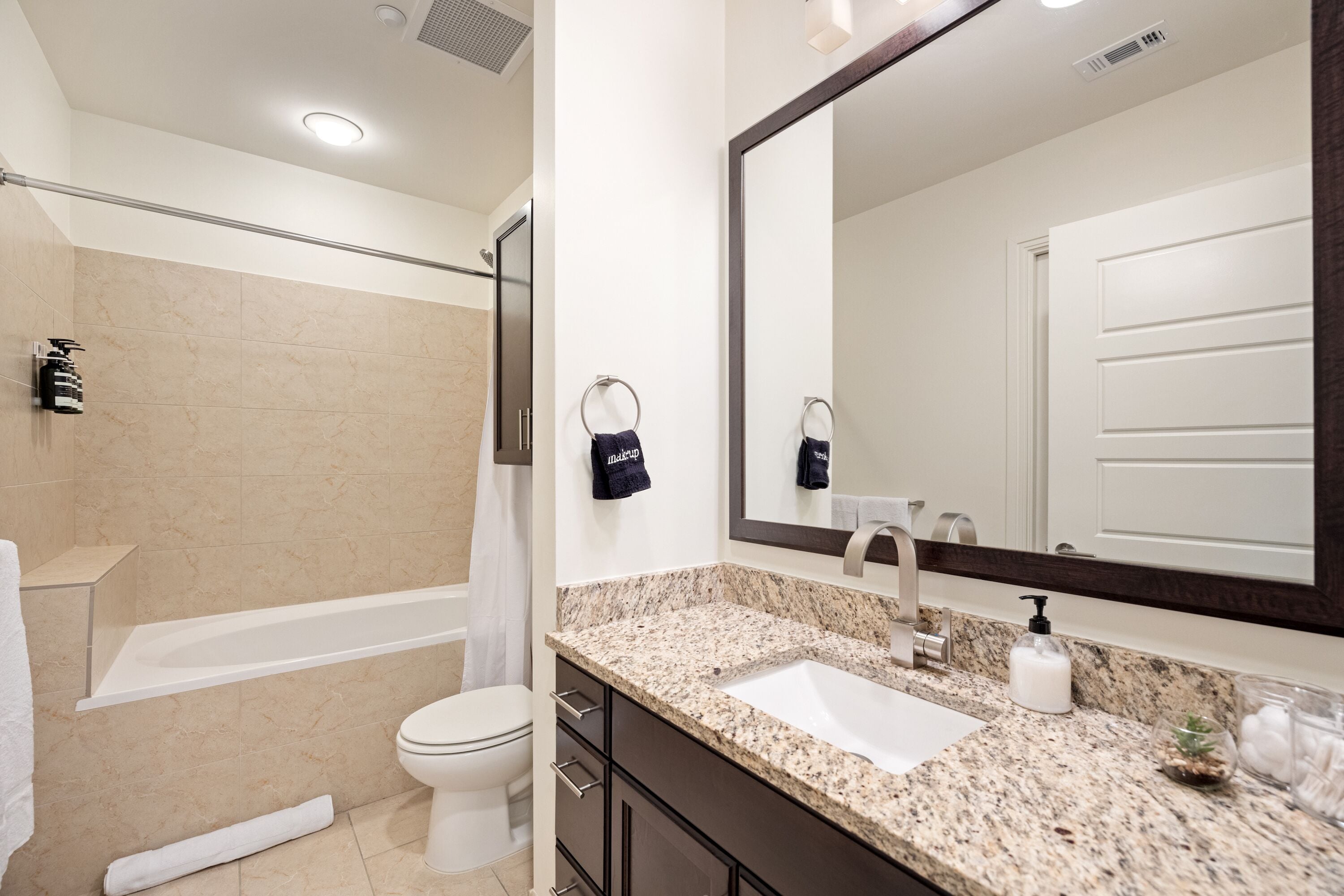 A modern bathroom with a bathtub, toilet, and sink.