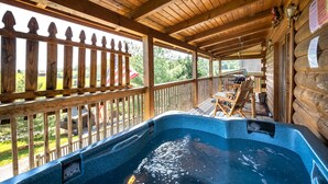 A wooden deck with a hot tub, wooden railing, and a table with chairs. - Deer Run, Free Attraction Tickets, Hot Tub, Resort Playground, Near Dollywood!!! (Sevierville)