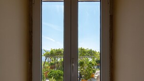 A room with a large window and a view of a garden. - Villa Maria (Kefalonia)