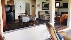 A spacious living area with a dining table and chairs, a sofa, and a television. - Quiet Lakefront property on Cassadaga Lake WiFi & 2 car parking. (Cassadaga)