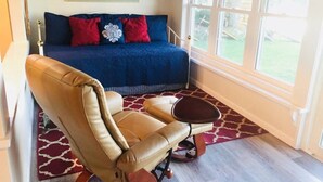 A room with a blue sofa, a leather armchair, a small table, and a patterned rug. - Quiet Lakefront property on Cassadaga Lake WiFi & 2 car parking. (Cassadaga)