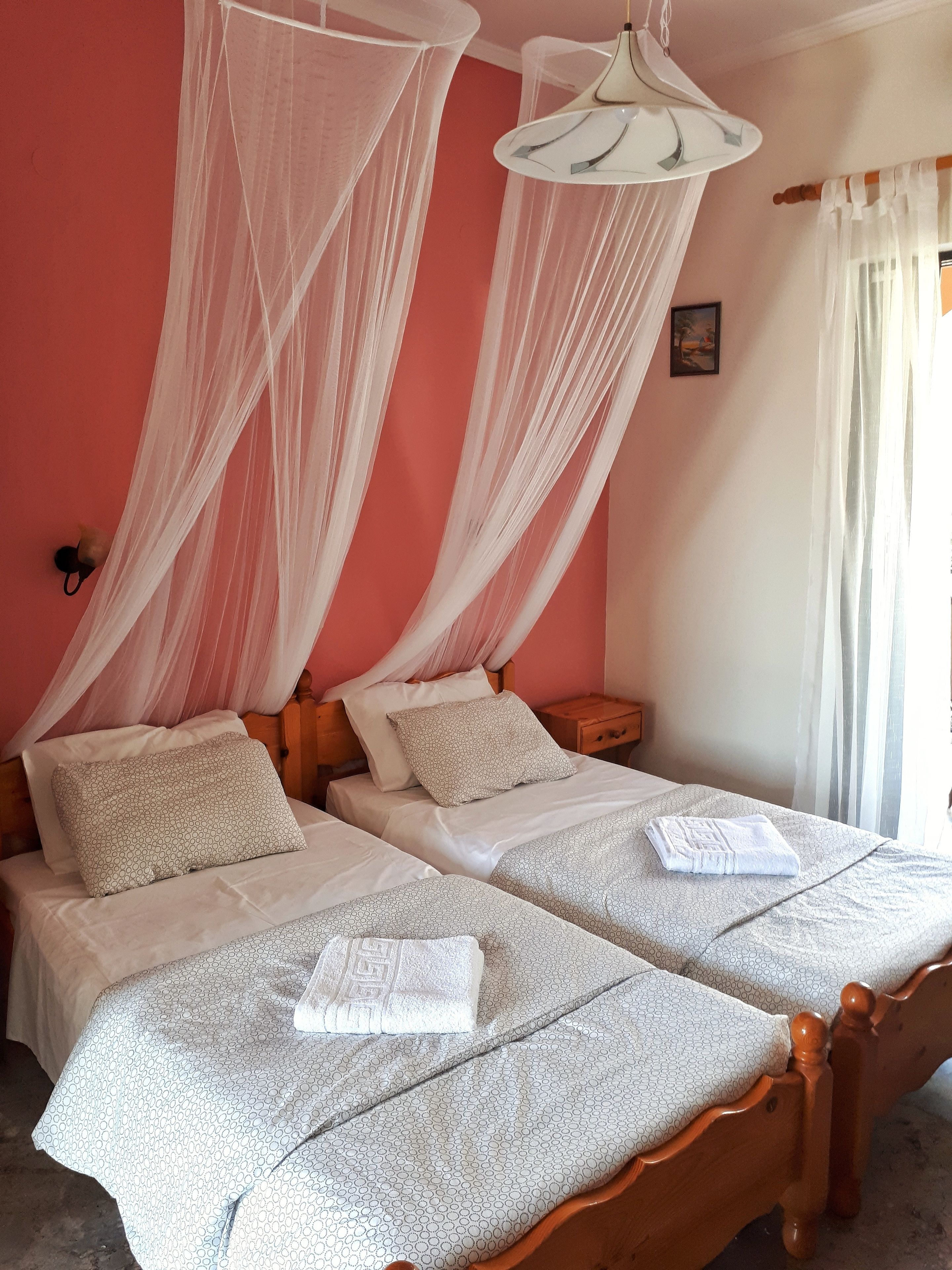 A double bed with a canopy, a bedside table, and a nightstand.