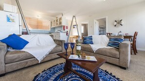 Ein Wohnzimmer mit zwei Sofas, einem Couchtisch und einem gemusterten Teppich.
